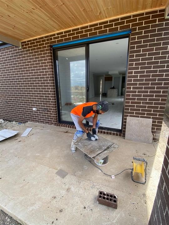United Tile Works tiler cutting tiles on a balcony