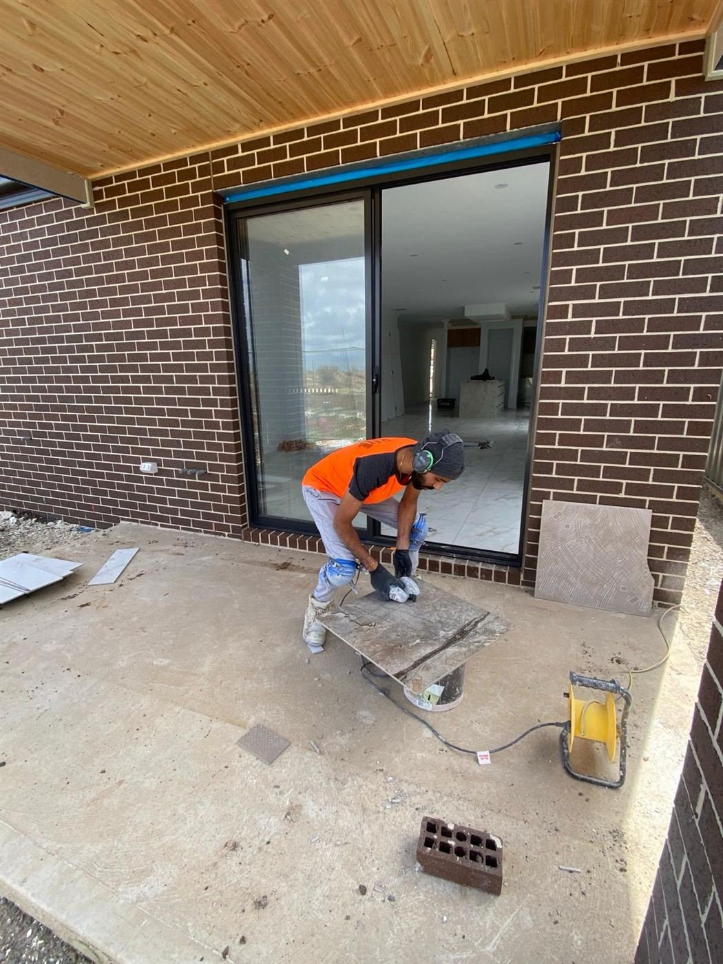 United Tile Works tiler cutting tiles on a balcony