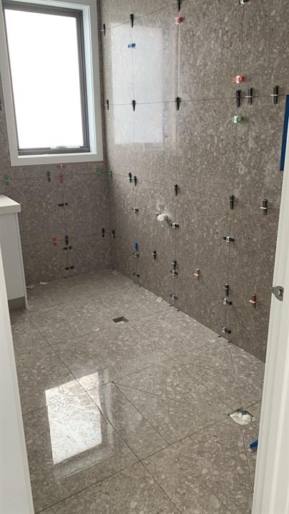 Marble-look bathroom wall tiles around a window
