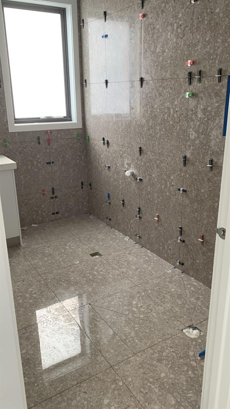 Marble-look bathroom tiles set with levelling clips