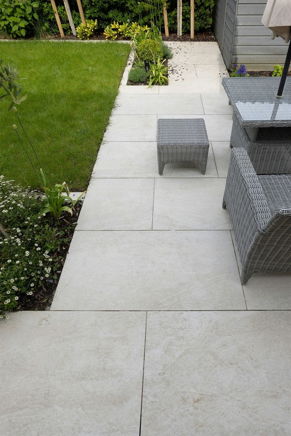 Large outdoor tiles laid as a garden path beside the lawn