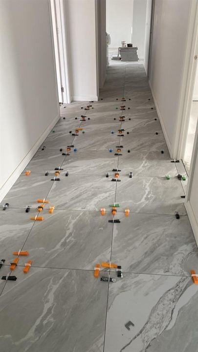 Large-format floor tiles laid along a hallway