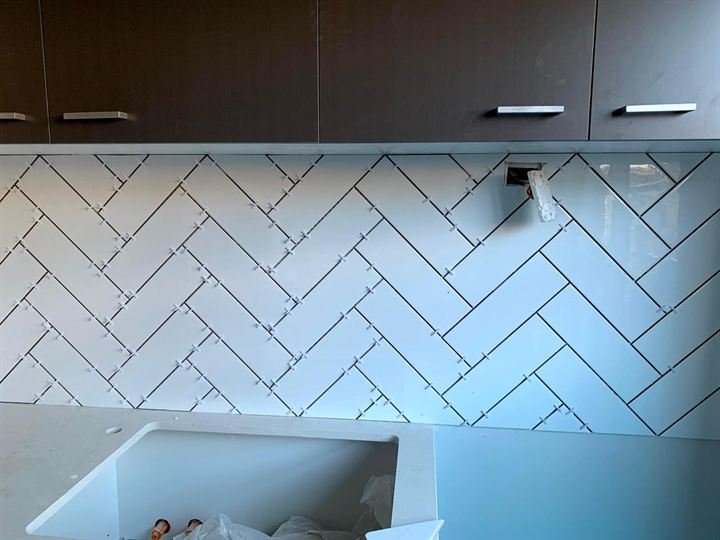 White herringbone tile splashback with dark grout